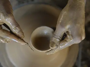 Seorang perajin tembikar membuat diyas atau pot minyak jelang Festival Diwali di pinggiran Hyderabad, India, 26 Oktober 2021. Diwali adalah salah satu festival besar yang dirayakan oleh umat Hindu, Jain, Sikh dan beberapa umat Buddha, terutama umat Buddha Newar. (NOAH SEELAM/AFP)