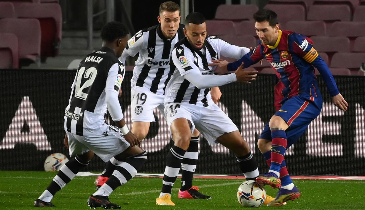 Striker Barcelona, Lionel Messi, berusaha melewati pemain Levante pada laga Liga Spanyol di Stadion Camp Nou, Senin (14/12/2020). Barcelona menang dengan skor 1-0. (AFP/Lluis Gene)