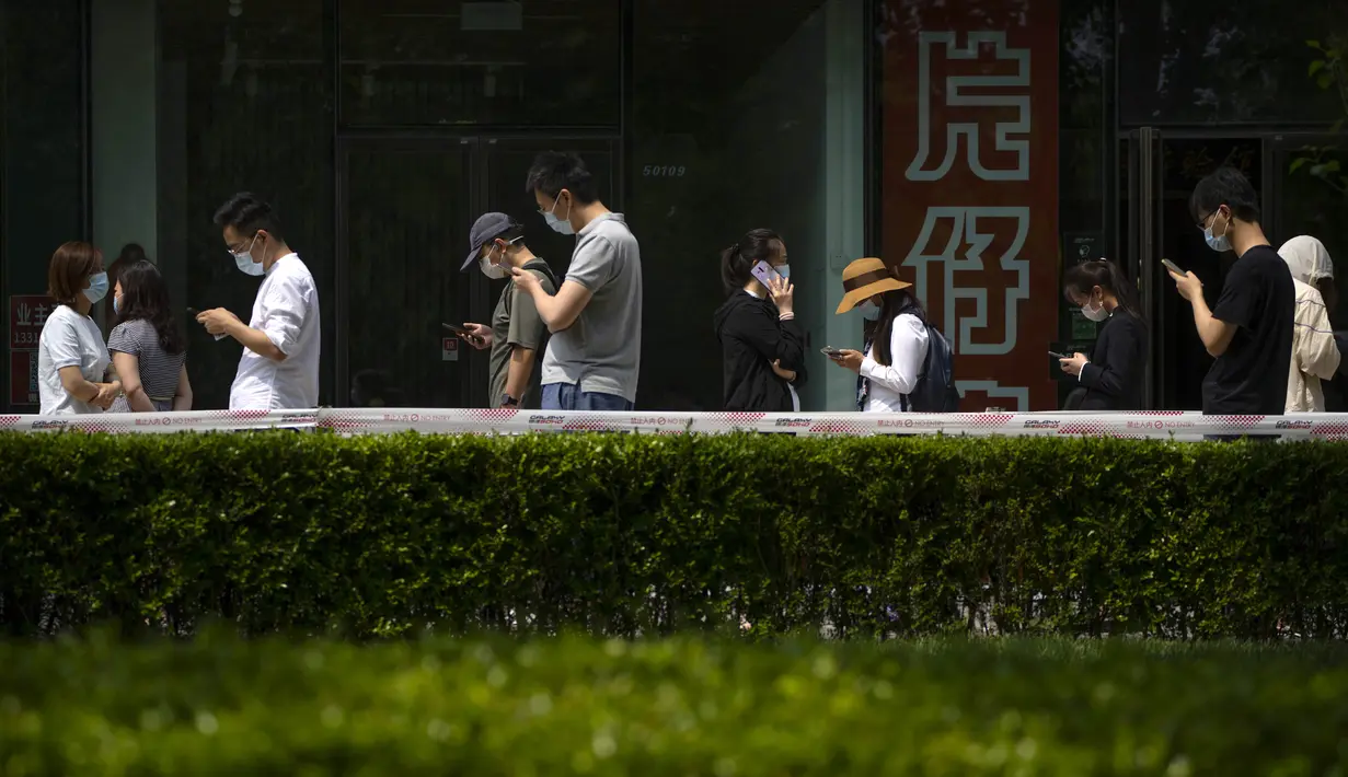 <p>Orang-orang antre tes COVID-19 di tempat pengujian virus corona di Beijing, Kamis (19/5/2022). Sebagian wilayah Beijing menghentikan pengujian massal harian yang telah dilakukan beberapa minggu terakhir, tetapi banyak tempat pengujian tetap sibuk karena syarat tes negatif COVID-19 dalam 48 jam terakhir untuk memasuki beberapa bangunan di ibu kota China. (AP Photo/Mark Schiefelbein)</p>