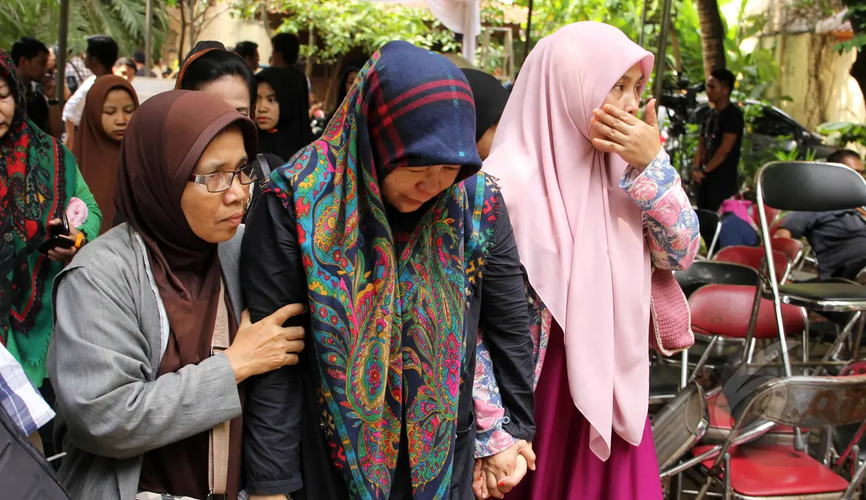 Air mata Uce Sriasih (tengah), istri Didi Widiatmoko alias Didi petet tak berhenti mengalir saat beberapa keluarga mendampinginya berjalan di rumah duka di kawasan Ciputat, Tangsel, Jumat (15/5/2015). (Liputan6.com/Helmi Afandi)
