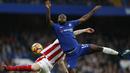 Aksi pemain Chelsea, Victor Moses (kanan) melakukan duel dengan pemain Stoke City, Charlie Adam pada lanjutan Premier League di Stamford Bridge, London (30/12/2017). Chelsea menang 5-0. (AFP/Ian Kington)