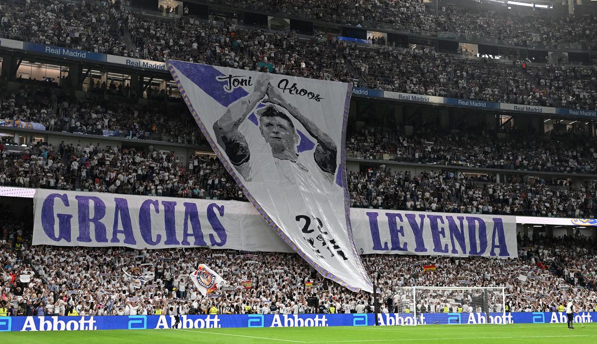 Fans Real Madrid membuat koreografi bertuliskan "Terima kasih legenda" saat upacara perpisahan Toni Kroos sebelum laga Liga Spanyol 2023/2024 melawan Real Betis di Santiago Bernabeu, Madrid, Spanyol, Minggu (26/05/2024) dini hari WIB. Kroos memutuskan untuk pensiun dari sepak bola setelah Euro 2024 nanti. (AFP/Javier Soriano)