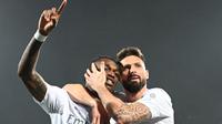 Penyerang AC Milan, Rafael Leao (kiri) melakukan selebrasi bersama Olivier Giroud setelah mencetak gol saat pertandingan sepak bola Serie A Italia melawan Fiorentina di Stadion Artemio Franchi, di Florence pada tanggal 30 Maret 2024. (Alberto PIZZOLI/AFP)