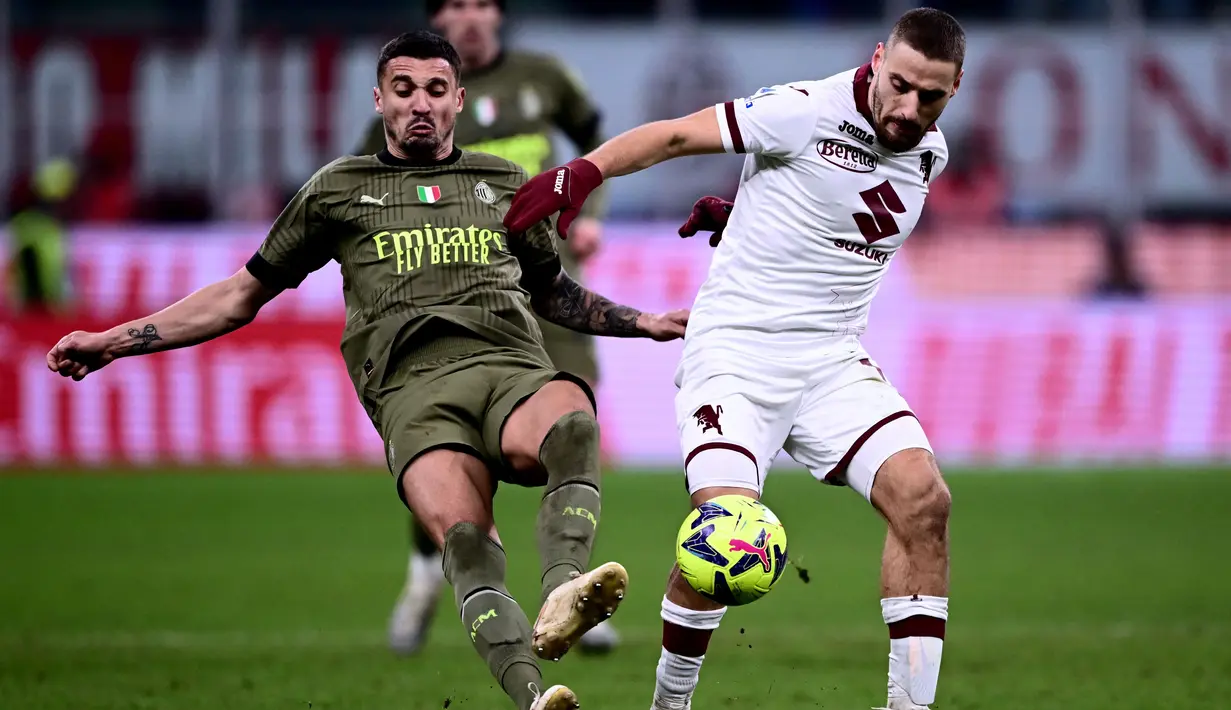 Gelandang AC Milan Rade Krunic (Kiri) dan gelandang Torino Nikola Vlasic saling berebut bola dalam duel pekan ke-22 Serie A 2022-2023, Sabtu (11/2/2023) dini hari WIB. Milan menjadi tim keempat yang mencapai 3.000 laga di Serie A setelah Inter, AS Roma, dan Juventus.  (Photo by Marco BERTORELLO / AFP)