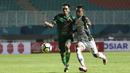 Gelandang PSMS Medan, Frets Butuan, berebut bola dengan gelandang PS Tira, Manahati Lestusen, pada laga Liga 1 di Stadion Pakansari, Jawa Barat, Rabu (5/12). PSMS kalah 2-4 dari PS Tira. (Bola.com/Yoppy Renato)