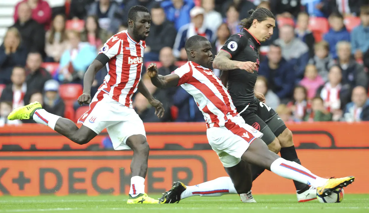 Bek Stoke City, Kurt Zouma, berebut bola dengan bek Arsenal, Hector Bellerin, pada laga Premier League di Stadion Bet365, Sabtu (19/8/2017). Stoke City menang 1-0 atas Arsenal. (AP/Rui Vieira)