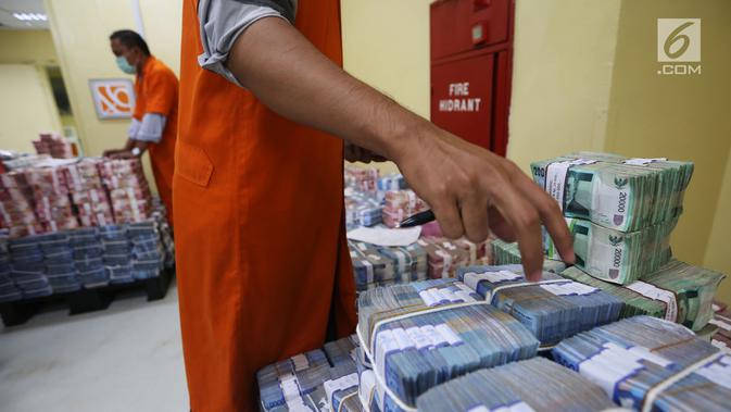 Petugas menata tumpukan uang kertas di Cash Center Bank BNI di Jakarta, Kamis (6/7). Nilai tukar rupiah terhadap dolar Amerika Serikat (USD) pada sesi I perdagangan hari ini masih tumbang di kisaran level Rp13.380/USD. (Liputan6.com/Angga Yuniar)