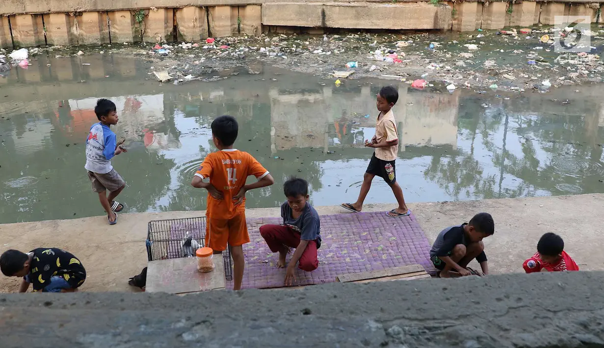 Anak-anak bermain di bantaran anak Sungai Ciliwung, Jakarta, Rabu (6/6). Meskipun tidak layak sebagai tempat bermain, namun lokasi itu menjadi tempat bagi anak-anak di kawasan tersebut untuk menunggu waktu berbuka. (Liputan6.com/Immanuel Antonius)