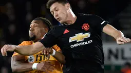 Gelandang Manchester United, Nemanja Matic melompat saat berebut bola dengan pemain Wolverhampton Wanderers, Adama Traore pada babak ketiga Piala FA di Molineux, Sabtu (4/1/2020). Wolverhampton dan MU dipaksa untuk melakukan laga ulangan di Old Trafford usai bermain imbang tanpa gol. (AP/Rui Vieira)