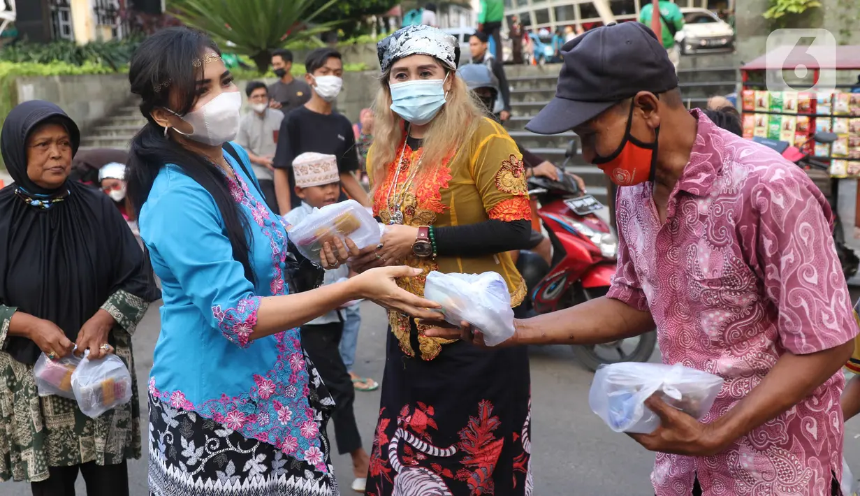 Sejumlah perempuan dengan mengenakan kebaya membagikan takjil untuk berbuka puasa bagi pengendara yang melintas di kawasan Tangerang, Banten, Rabu (21/4/2021). Pembagian takjil dengan mengenakan kebaya tersebut untuk merayakan Hari Kartini. (Liputan6.com/Angga Yuniar)