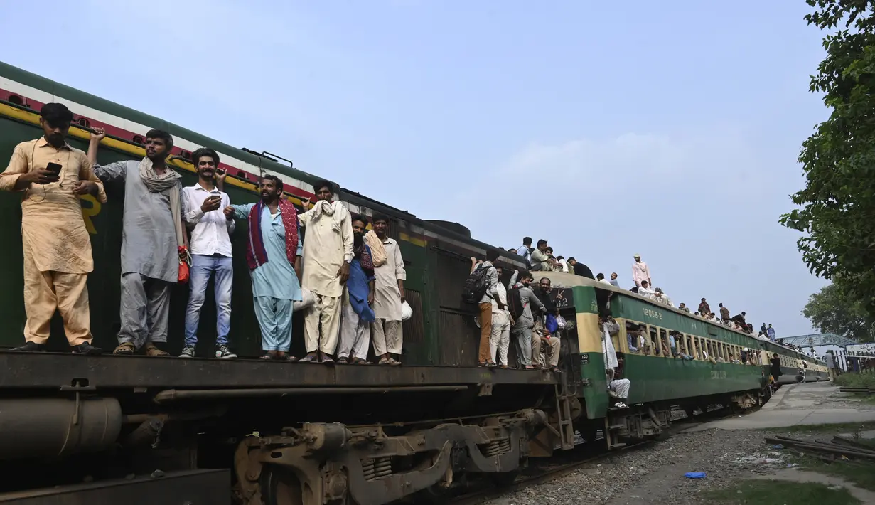 Warga Pakistan menaiki kereta api ke kampung halaman untuk merayakan Idul Adha, atau "Hari Raya Kurban," di Lahore, Pakistan, Kamis (7/7/2022). Selama hari raya, yang di sebagian besar tempat berlangsung selama empat hari, umat Islam menyembelih domba atau sapi dan membagikan sebagian dagingnya kepada orang miskin. (AFP/Arif Ali)
