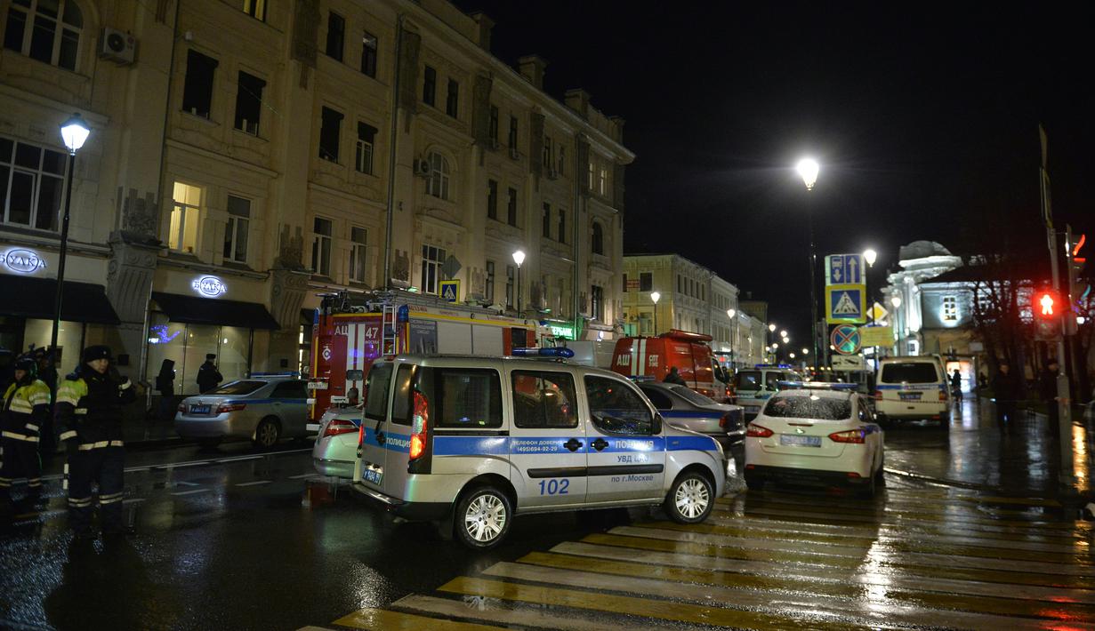Pemadam kebakaran dan polisi berada di halte bus yang terkena ledakan di Moskow, Rusia, Senin (7/12). Tiga orang luka terkena pecahan kaca. Bahan peledak diperkirakan dilemparkan dari mobil atau bangunan perumahan di dekatnya. (AFP/NATALIA Kolesnikova)