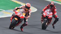 Aksi Marc Marquez dibayangi oleh pebalap Ducati Danilo Petruci pada balapan yang berlangsung di Sirkuit Le Mans, Prancis, Minggu (19/5). Marc Marquez raih podium teratas mengungguli tiga pebalap Ducati. (AFP/ Jean Francois Monier)