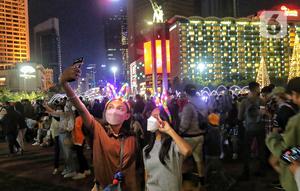 Warga memadati Car Free Night (CFN) pada malam pergantian tahun baru 2023 di kawasan Bundaran Hotel Indonesia, Jakarta, Sabtu (31/12/2022). Banyak warga yang berkumpul merayakan pergantian tahun baru sambil berswafoto, menikmati kuliner, berjalan hingga bersepeda santai. (Liputan6.com/Angga Yuniar)