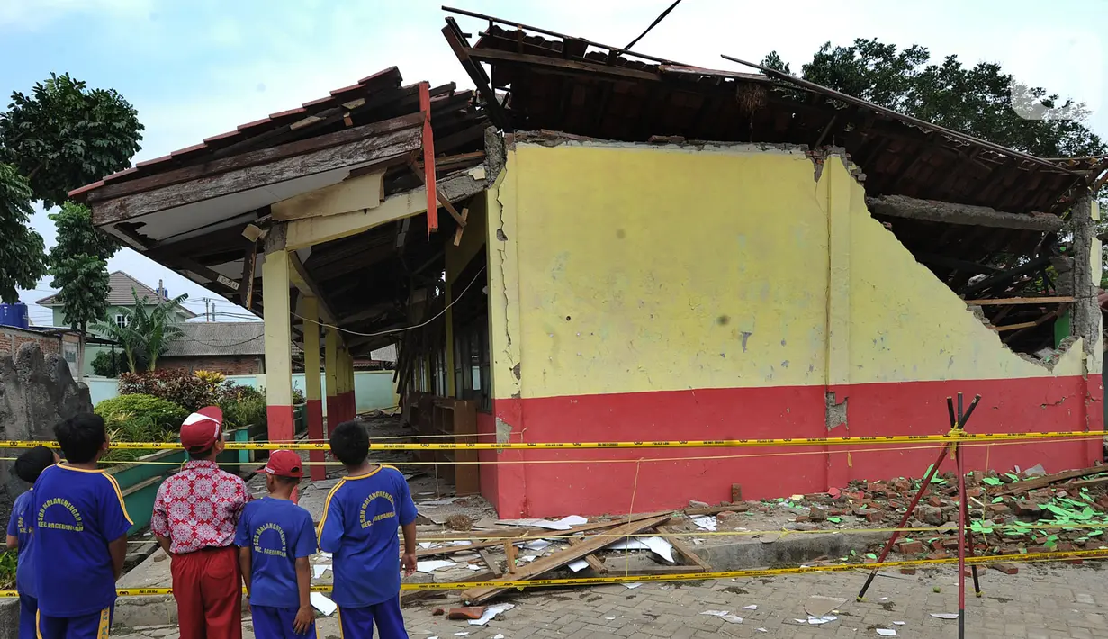 Siswa melihat bangunan sekolah yang ambruk di SDN Malangnengah II di Kampung Jaha, Desa Malang Negah, Kec. Pangedagang, Kabupaten Tangerang, Banten, Rabu (13/11/2019). Tiga ruang kelas di SD itu roboh akibat kontur tanah di lingkungan sekolah yang ambles karena hujan. (merdeka.com/Arie Basuki)