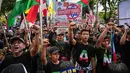 Sebagai informasi, Hari Al-Quds Internasional diperingati setiap Jumat terakhir bulan Ramadan. Tampak dalam foto, orang-orang memegang plakat dan bendera Palestina selama berunjuk rasa memperingati Hari Al-Quds, di Surabaya, Jawa Timur, Jumat (13/3/2026). (Juni KRISWANTO/AFP)