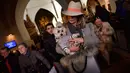 Seorang wanita menggendong anjing peliharaannya pada peringatan Hari santo Antonius di gereja Saint Pablo, Spanyol, Rabu (17/1). Banyak yang percaya pemberkatan ini memberikan kesehatan dan kesejahteraan bagi hewan serta pemiliknya. (AP/Alvaro Barrientos)