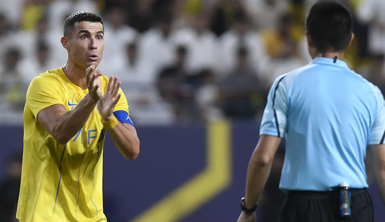 Pemain Al-Nassr, Cristiano Ronaldo (kiri) melakukan protes terhadap keputusan wasit yang memimpin laga play off Liga Champions Asia 2023/2024 antara Al-Nassr melawan Al-Ahli Dubai di KSU Stadium, Rabu (23/8/2023) WIB. (AFP/Yazid al-Duwihi)