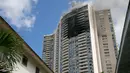 Kebakaran yang terjadi di apartemen Marco Polo, Honolulu (14/7). Hingga saat ini tim pemadam kebakaran masih terus berusaha menjinakkan api di apartemen tersebut. (AP Photo / Marco Garcia)