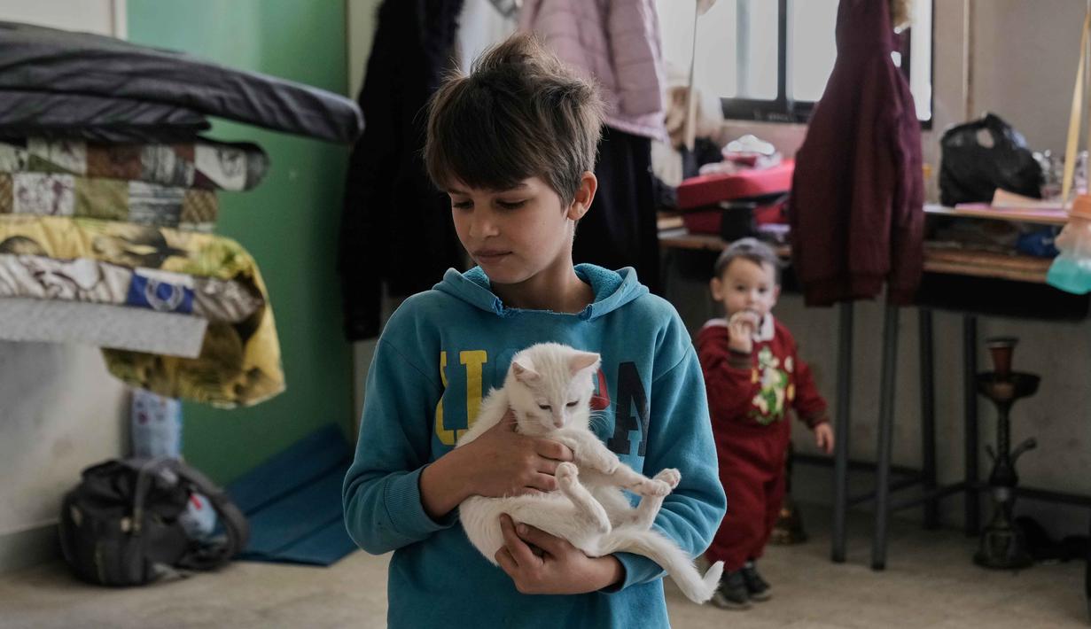 Jumlah pengungsi terus meningkat dengan lebih dari 100.000 dalam satu hari. Tampak dalam foto, seorang anak laki-laki pengungsi yang menghindari serangan udara Israel di Lebanon selatan dan Dahiyeh, di Institut Teknik Bir Hassan yang telah diubah menjadi tempat penampungan, Beirut, Rabu 11 Maret 2026. (AP Photo/Bilal Hussein)