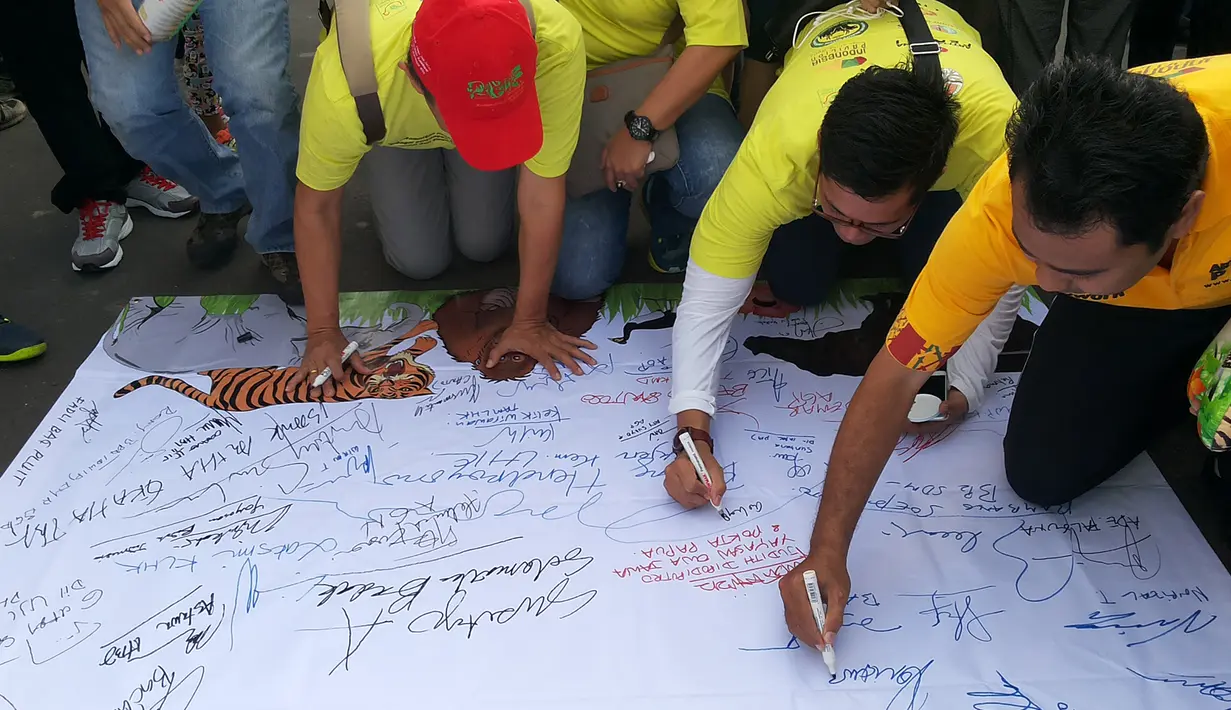 Peserta menandatangani Spanduk Deklarasi Keanekaragaman Hayati dibentangkan saat aksi jalan santai di kawasan Bundaran HI, Minggu (15/11/2015). Aksi ini untuk merayakan Hari Cinta Puspa dan Satwa Nasional 2015. (Media center AGP-AGN)