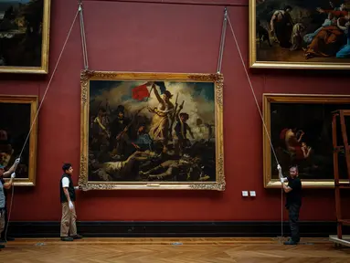 Pekerja galeri memindahkan lukisan "Liberty Leading the People" karya Delacroix (1798-1863) dari dinding Museum Louvre menjelang pekerjaan restorasi yang dijadwalkan berlangsung hingga musim semi 2024 di Paris, 20 September 2023. (Dimitar DILKOFF / AFP)