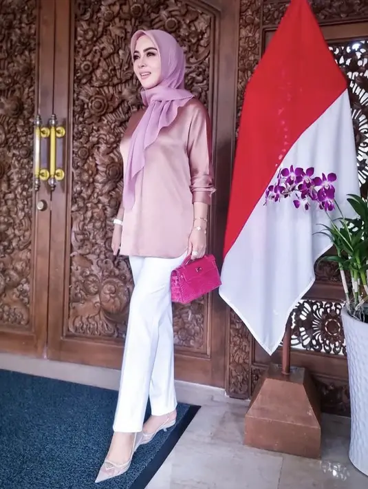 Gaya Syarini ini juga cukup simple untuk diikuti, cukup kenakan atasan satin pink yang serasi dengan warna kerudungmu. Padukan dengan celana putih. (@princessyahrini)