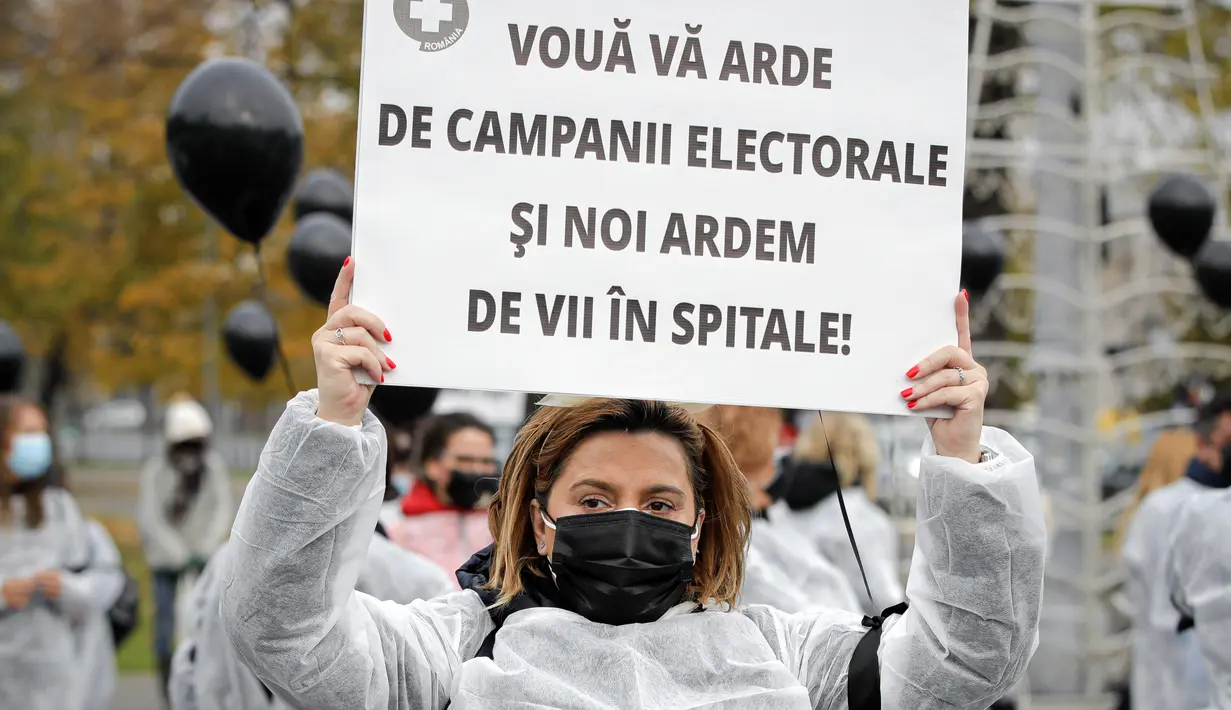 Para petugas medis yang mengenakan masker memegang balon hitam di Bucharest, Rumania, Selasa (17/11/2020). Aksi tersebut untuk mengenang pasien COVID-19 yang tewas dalam kebakaran di instalasi gawat darurat rumah sakit di Piatra Neamt, Rumania pada 14 November 2020 lalu. (AP Photo/Vadim Ghirda)