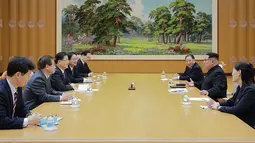 Pemimpin Korea Utara Kim Jong-un (kanan tengah) menerima rombongan delagasi dari Korea Selatan di Pyongyang (5/3). Dalam pertemuan itu, Kim Jong-un membahas cara untuk mengurangi ketegangan di semenanjung Korea. (AFP/Handout)