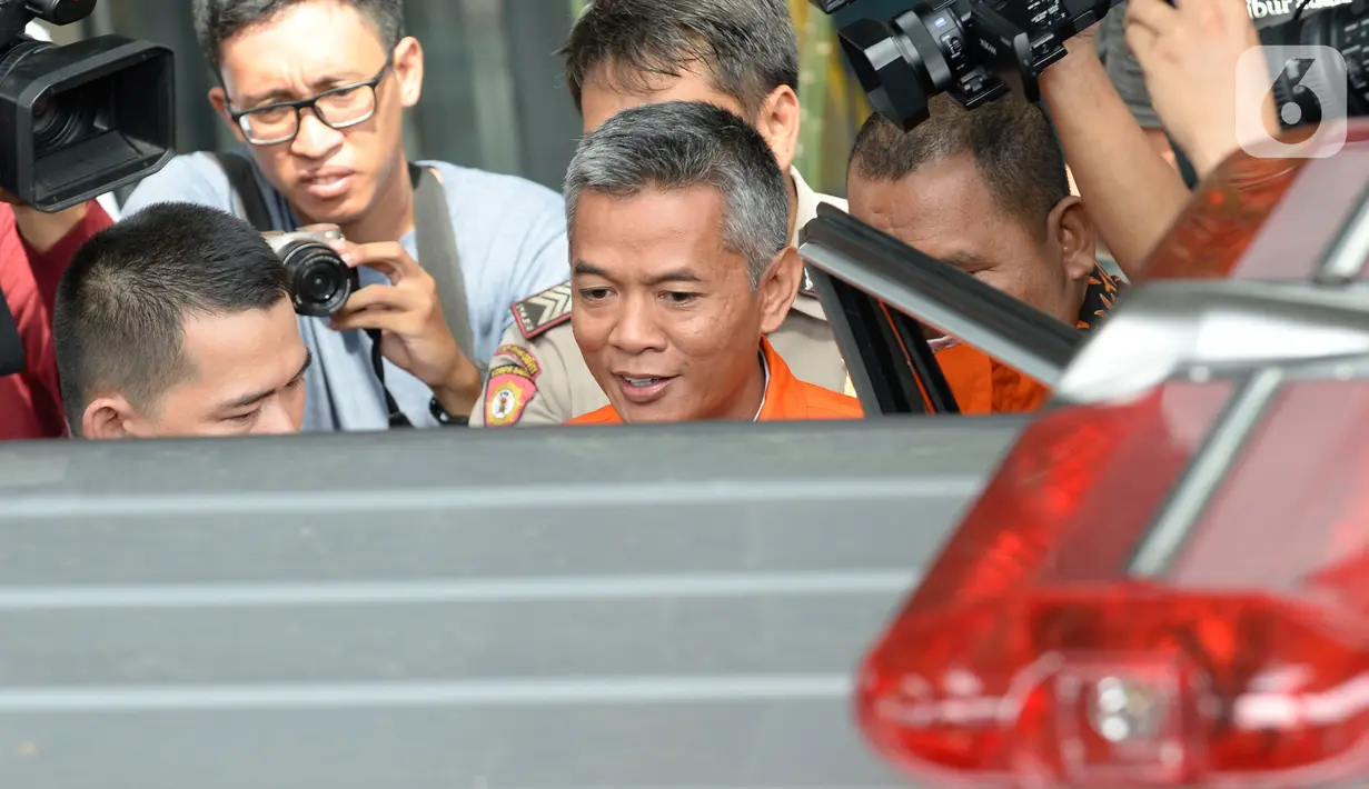 Komisioner KPU Wahyu Setiawan (rompi tahanan) bersiap naik mobil tahanan saat akan meninggalkan gedung KPK, Jakarta, Rabu (15/1/2020). Wahyu Setiawan diperiksa perdana usai ditetapkan sebagai tersangka terkait dugaan penerimaan suap penetapan anggota DPR terplih 2019-2020. (merdeka.com/Dwi Narwoko)