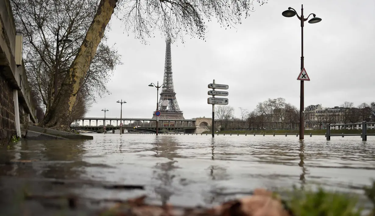 Banjir yang merendam tepi sungai Seine di dekat menara Eiffel dan distrik Beaugrenelle, Paris (23/1). Tingkat sungai Seine naik ke ketinggian 4.57 meter (15 kaki), beberapa meter lebih tinggi dari tingkat normalnya. (AFP Photo/Ludovic Marin)