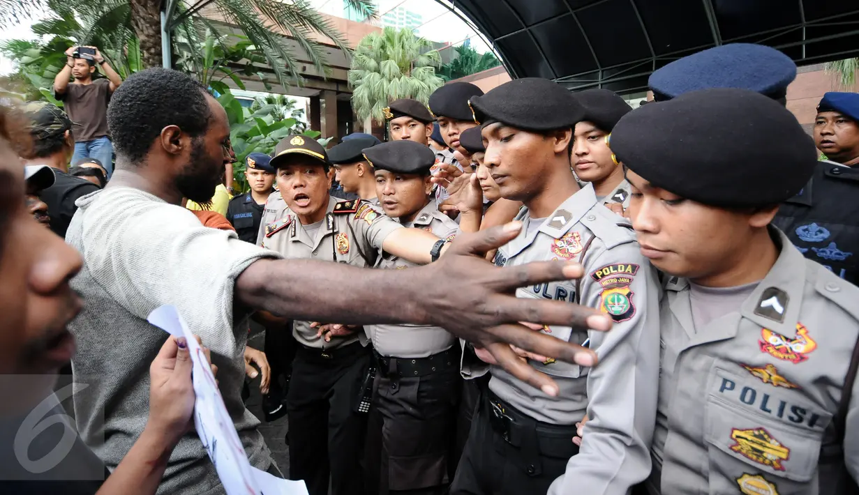 Massa yang tergabung dalam Aliansi Mahasiswa Papua dan FRI-West Papua berusaha saling menenangkan saat berunjuk rasa di depan kantor PT Freeport di Jakarta, Jumat (7/4). Mereka menuntut penutupan PT Freeport. (Liputan6.com/Helmi Fithriansyah)