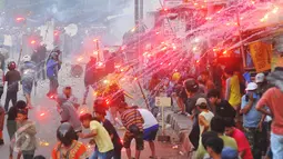 Sejumlah orang mencoba menghindari penyerangan dengan petasan dalam tawuran antarwarga di dekat Stasiun Manggarai, Jakarta Selatan, Minggu (8/1). Tawuran ini cukup mencekam karena sejumlah warga membawa senjata tajam. (Liputan6.com/Angga Yuniar)