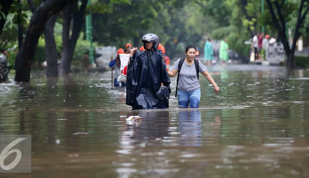 Warga berjalan ditengah banjir di kawasan di Hang Lekiu, Kebayoran Baru, Jakarta, Jumat (11/11). Hujan deras disertai angin yang mengguyur wilayah Jakarta, mengakibatkan daerah ini banjir. (Liputan6.com/Johan Tallo)