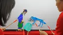 Para seniman wayang menampilkan permainan wayang kulit di Sekolah Dasar Xiyoucun di Kota Shahe, Provinsi Hebei, China utara, pada 24 November 2020. (Xinhua/Fan Shihui)