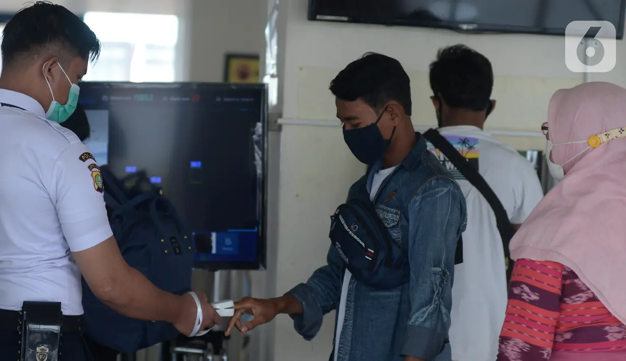 Petugas keamanan mengecek pemudik saat arus balik Lebaran di Terminal Pulogebang, Jakarta, Jumat (21/5/2021). Pada hari ini, ada tiga pemudik terindikasi positif COVID-19. (merdeka.com/Imam Buhori)