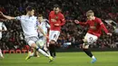 Bek Colchester United, Luke Prosser berusaha menahan bola tembakan bek Manchester United, Brandon William pada perempat final Piala Liga Inggris di Old Trafford (18/12/2019). MU menang telak 3-0 atas Colchester United dan melaju ke semifinal. (AP Photo/Jon Super)