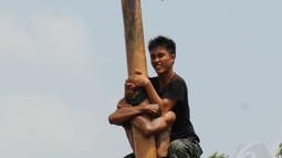 Ekpresi salah satu peserta lomba panjat pinang dalam rangka memeriahkan HUT RI ke-69 di kawasan Tugu Monas, Jakarta, (31/8/2014). (Liputan6.com/Helmi Fithriansyah)