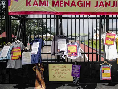 Instalasi pakaian korban kekerasan seksual dipajang di depan gerbang Gedung DPR, Jakarta, Rabu (22/12/2021). Massa yang tergabung dalam Jaringan Pembela Hak Perempuan Korban Kekerasan Seksual mendesak DPR mengesahkan RUU TPKS sebagai RUU Inisiatif DPR RI. (Liputan6.com/Faizal Fanani)