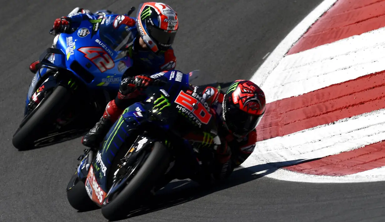 Pembalap Fabio Quartararo menikung diikuti Alex Rins pada pertandingan balap MotoGP Portugal di Sirkuit Algarve International dekat Portimao, Portugal, Minggu (18/4/2021). Fabio Quartararo menjadi juara dan merangsek ke urutan pertama klasemen sementara dengan total 61 poin. (AP Photo/Jose Breton)