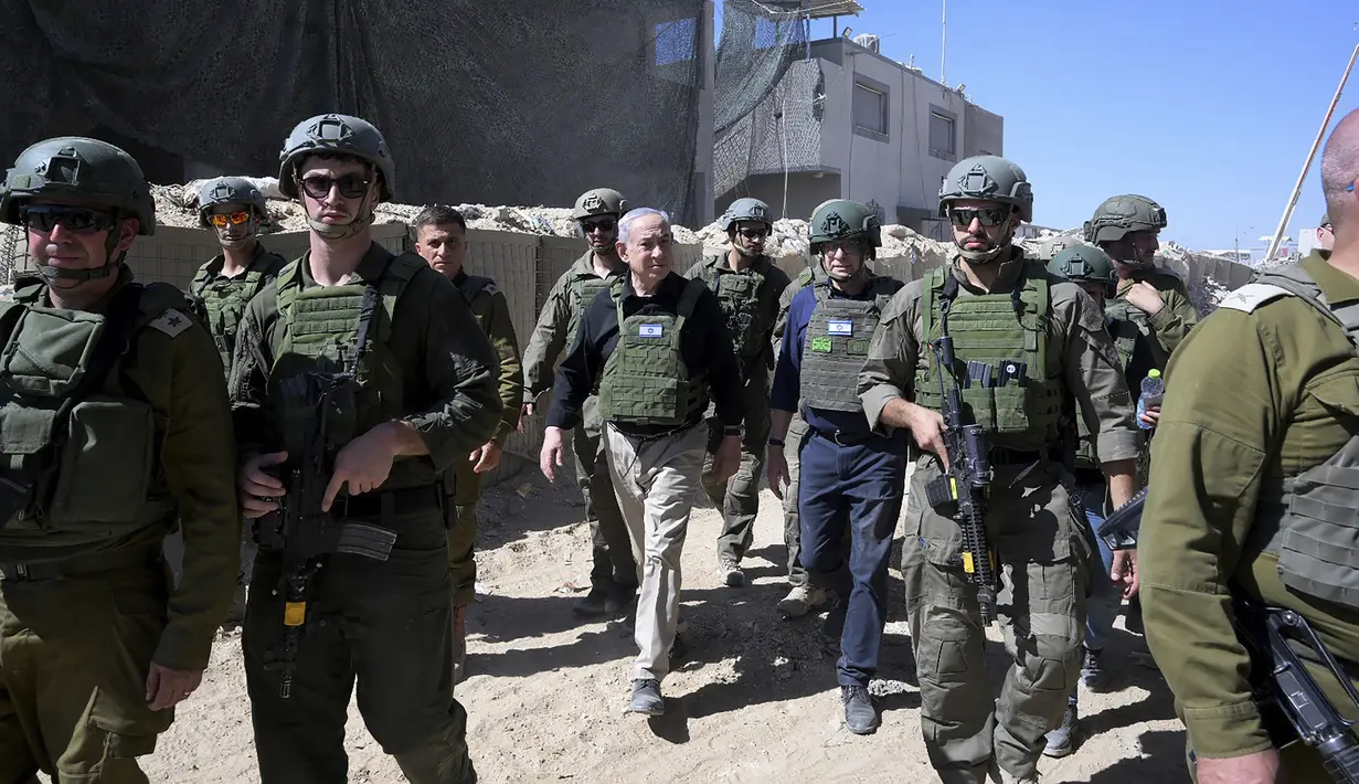 Perdana Menteri Israel Benjamin Netanyahu (tengah) berjalan bersama pasukan Israel saat melakukan kunjungan mendadak ke Rafah di Jalur Gaza selatan, Kamis (18/7/2024). (Avi Ohayon/Israel Prime Minister's Office via AP)