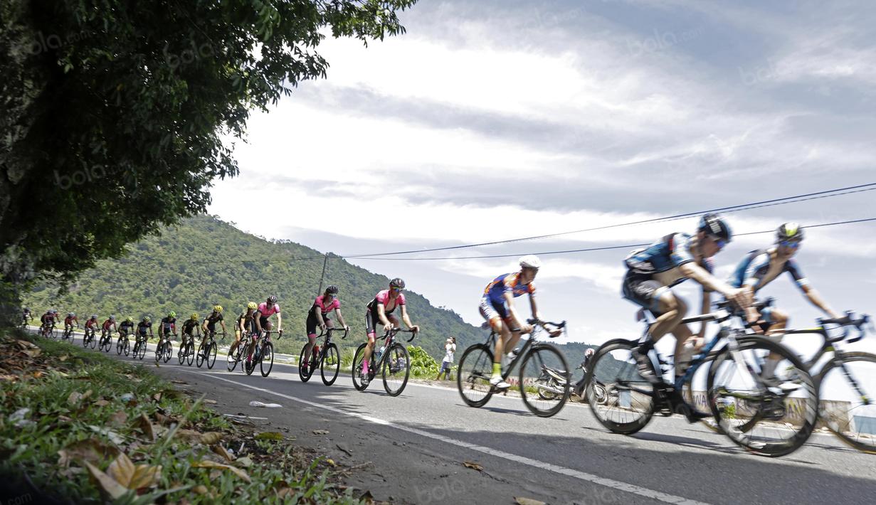 Pebalap Tour de Singkarak 2016 saat melintasi Teluk Bayur pada etape ke-5 Tour de Singkarak dari Pantai Carocok-Painan menuju pantai Gondoriah-Pariaman, Sumatera Barart. (Bola.com/Nicklas Hanoatubun)