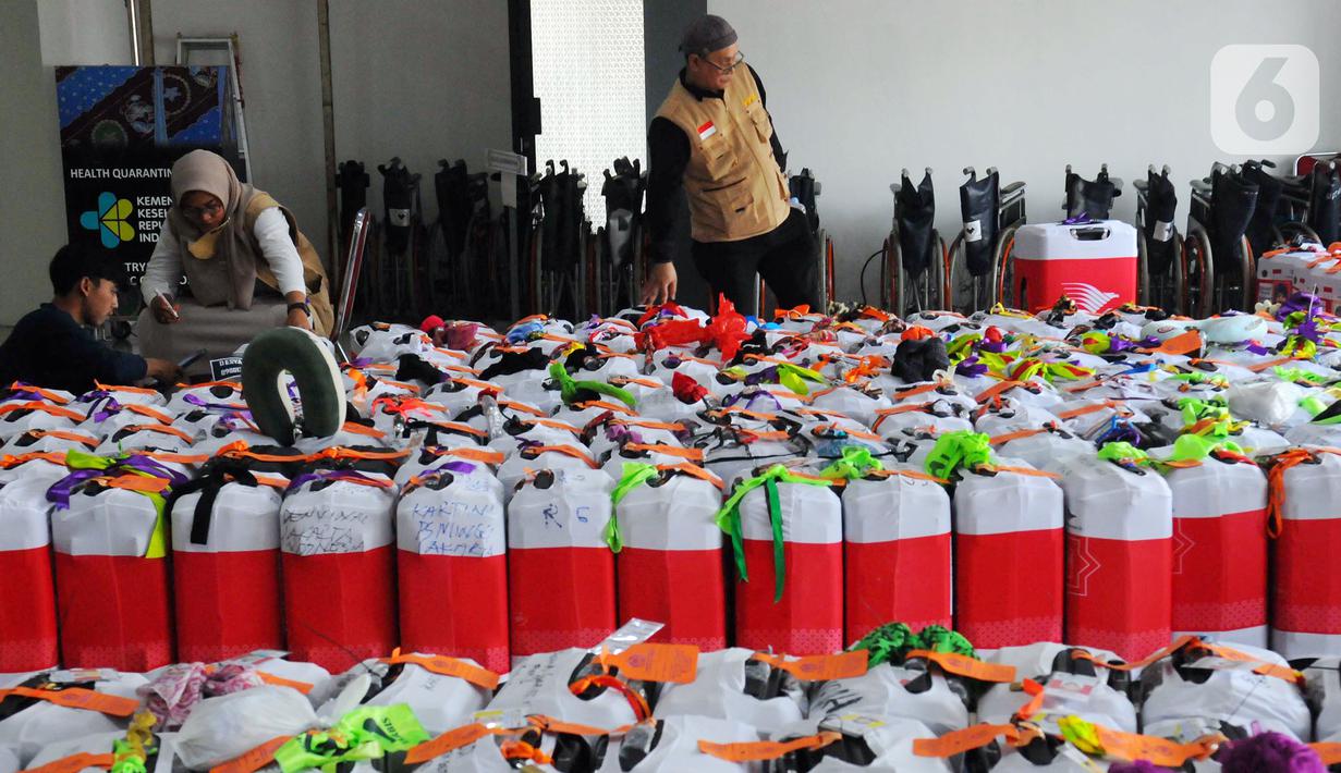 Petugas melakukan pengecekan koper para jemaah haji di Asrama Haji Pondok Gede, Jakarta, Selasa (23/5/2023). Keberangkatan jemaah haji kloter pertama akan dimulai pada Rabu, 24 Mei 2023. (merdeka.com/Imam Buhori)