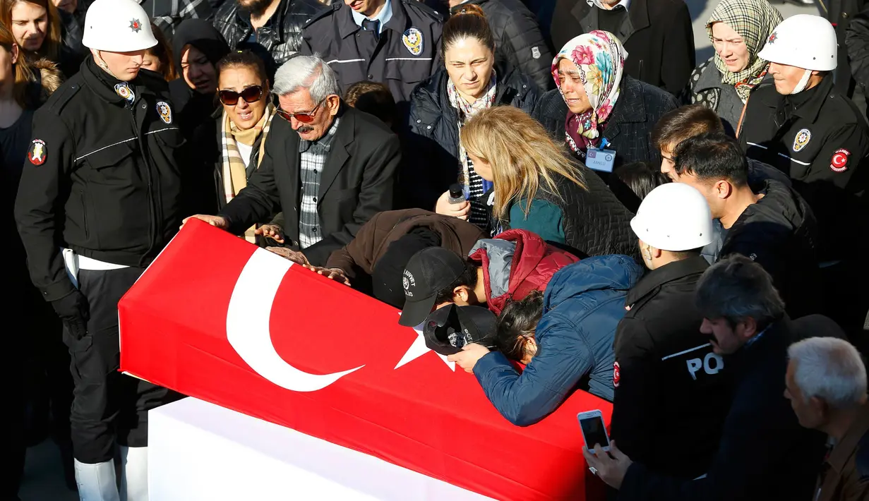 Suasana duka saat keluarga dari anggota Polisi yang tewas dalam ledakan bom melepas kepergian jenazah di Istanbul, Turki (11/12). Presiden Tayyib Erdogan mengatakan ledakan tersebut sebagai serangan teroris terhadap polisi dan warga. (Reuters/Murad Sezer)