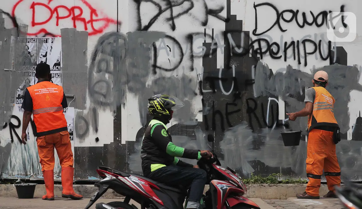 Petugas PPSU DKI Jakarta membersihkan coretan di kawasan Kebon Sirih, Jakarta Pusat, Sabtu (10/10/2020). Dinas kebersihan dari PPSU dan Satpel DLH melakukan penghapusan coretan di fasilitas umum oleh pengunjuk rasa saat demonstrasi tolak Omnibus Law UU Cipta Kerja. (Liputan6.com/Johan Tallo)
