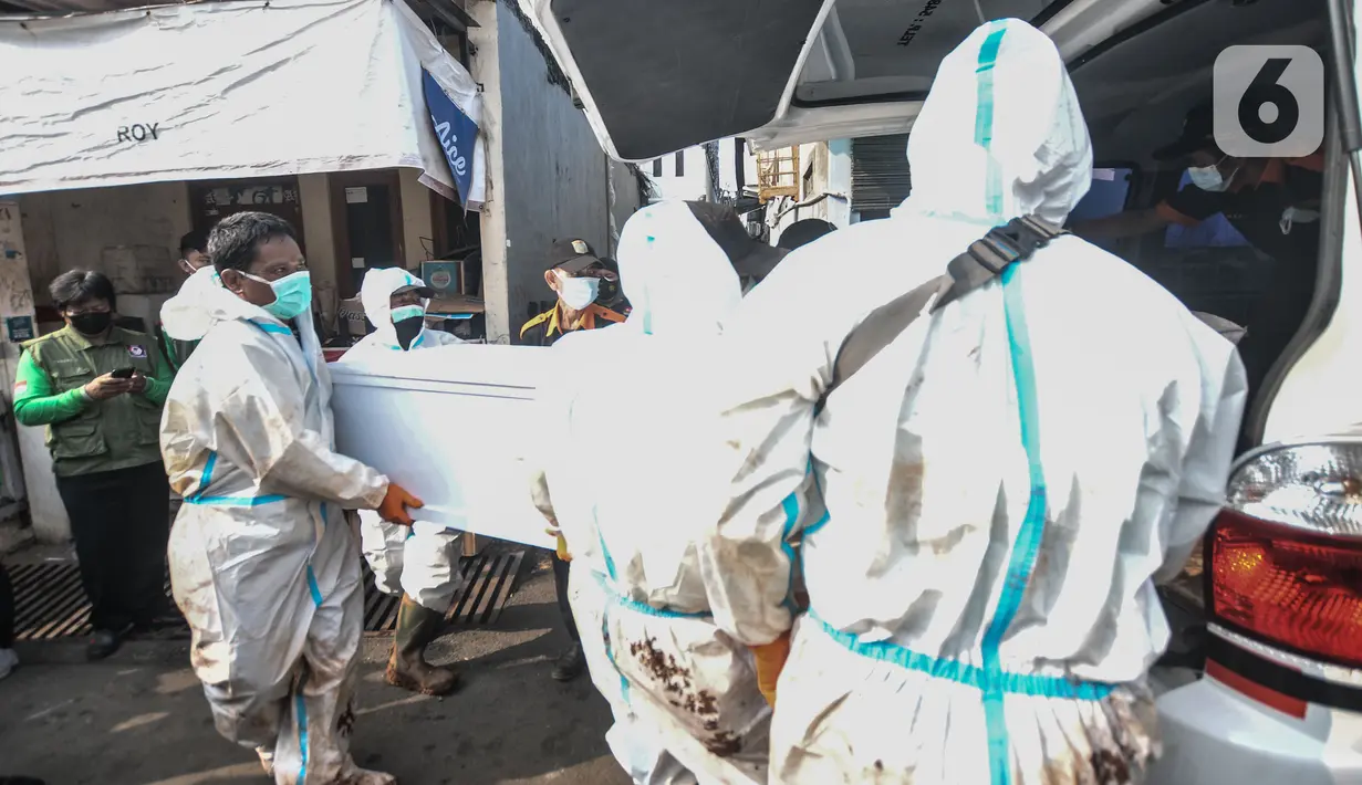 Petugas membawa peti jenazah almarhum Trio Fauqi Virdaus (22) sebelum dilakukan autopsi di Buaran, Jakarta Timur, Senin (24/5/2021). Jenazah Trio yang meninggal sehari setelah disuntik vaksin AstraZeneca akan menjalani autopsi di RSCM guna memastikan penyebab kematiannya. (merdeka.com/Iqbal S. Nugro