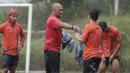Asisten pelatih Persija Jakarta, Sudirman, memberikan rompi kepada pemain saat latihan di Lapangan NYTC, Sawangan, Depok, Kamis (16/1/2020). Hujan deras beserta petir membuat latihan Persija Jakarta kali ini hanya berlangsung sekitar 25 menit. (Bola.com/M Iqbal Ichsan)