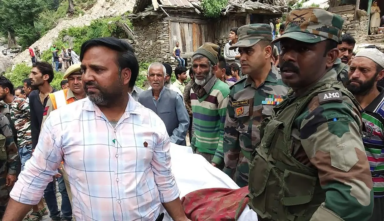 Petugas membawa korban kecelakaan bus di wilayah Kishtwar di negara bagian Jammu dan Kashmir (1/7/2019). Sekitar 35 orang tewas dan 22 orang terluka akibat bus sarat penumpang tersebut terjun ke jurang. (AFP Photo/STR)