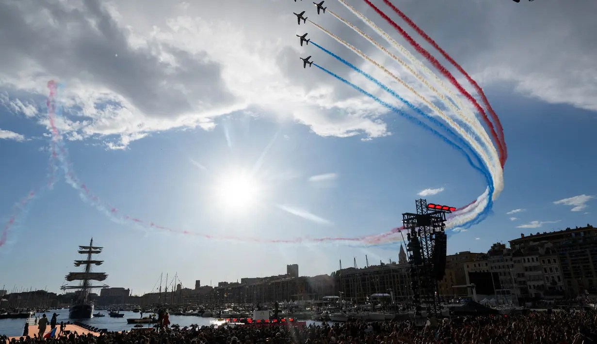 Tim terbang akrobatik elit Angkatan Udara Prancis "Patrouille de France" (PAF) terbang melewati kapal barque Belem bertiang tiga dari abad ke-19 Prancis di Vieux-Port (Pelabuhan Lama) di Marseille, pada tanggal 8 Mei 2024. (Nicolas TUCAT/AFP)