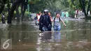 Warga berjalan ditengah banjir di kawasan di Hang Lekiu, Kebayoran Baru, Jakarta, Jumat (11/11). Hujan deras disertai angin yang mengguyur wilayah Jakarta, mengakibatkan daerah ini banjir. (Liputan6.com/Johan Tallo)